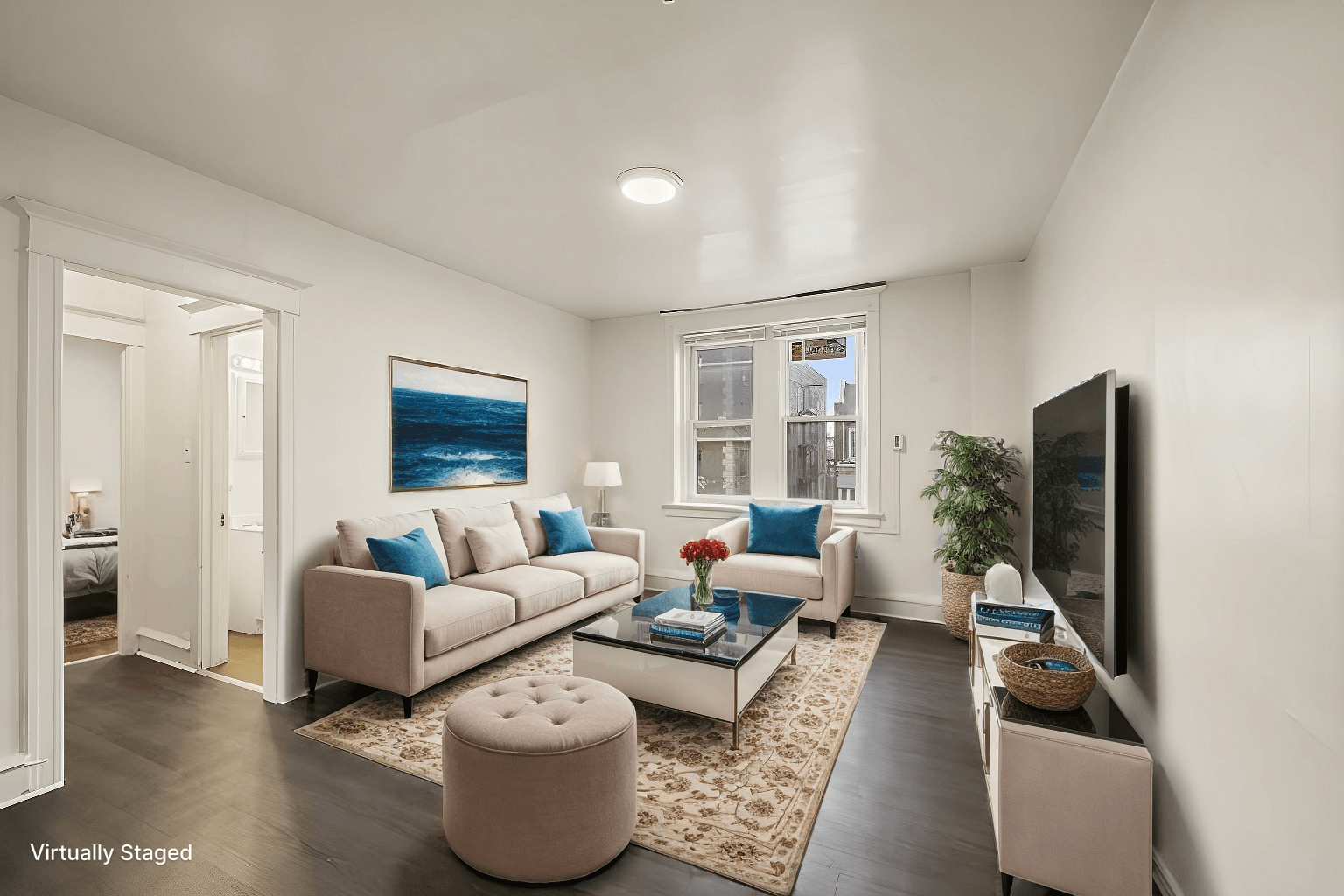 A living room with a couch, a coffee table, and a television.